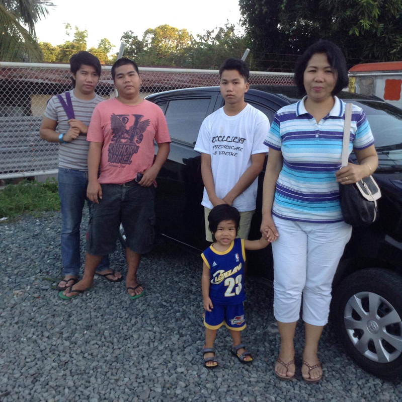 Pastor Roger's family posing beside the car, Toyota Wigo