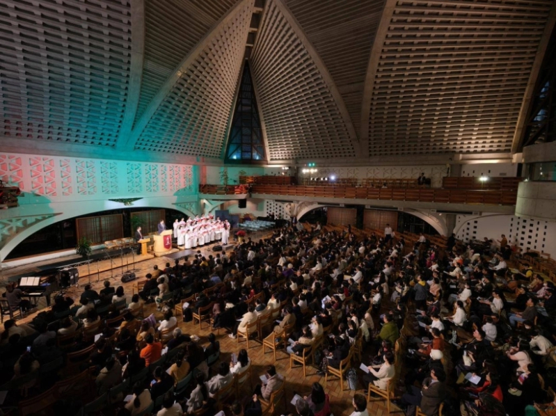 Attendees light up their phones during the STEMI Christmas Rally, creating a moving atmosphere with hundreds of glowing lights.